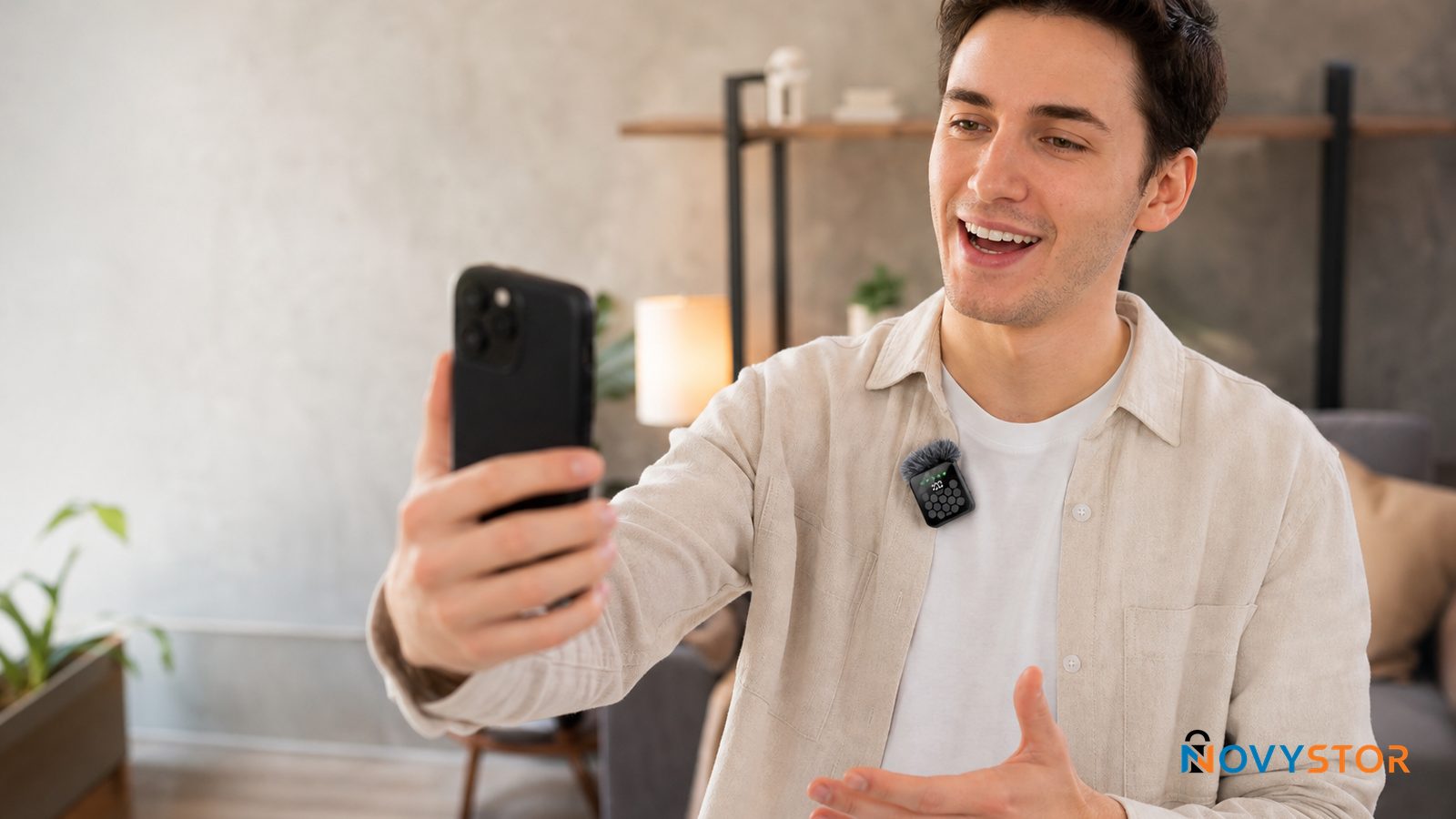 Persona grabando video con celular usando el micrófono lavalier inalámbrico Novystor enganchado en la solapa de su camisa