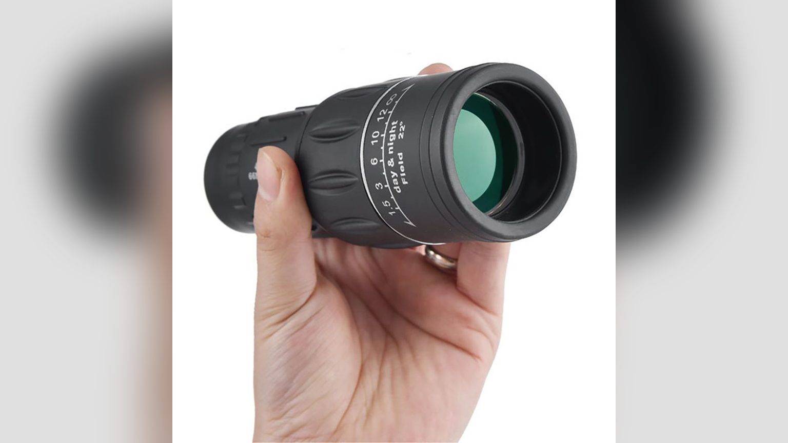 Lente objetivo de 52mm del monocular DSTARGAZE junto a una moneda chilena de $100 para comparar el tamaño